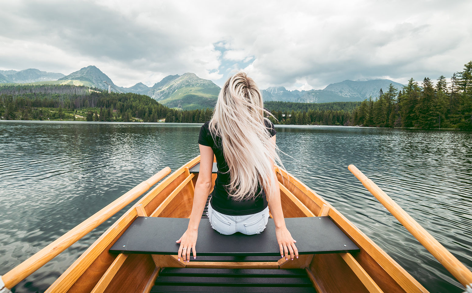 Young Blonde Woman Enjoying a Rowing Boat